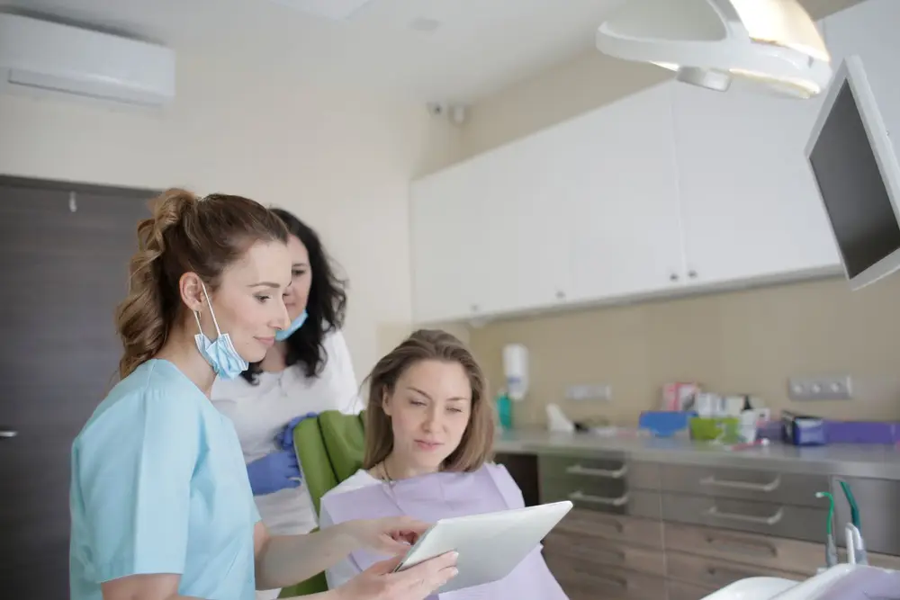 Dental team showing a patient information on a tablet